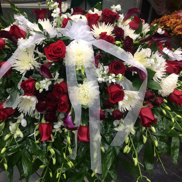 Large red and white floral spray with a sheer ribbon bow