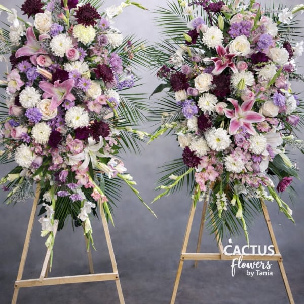 Two large standing floral sprays with pink, white, and purple blooms