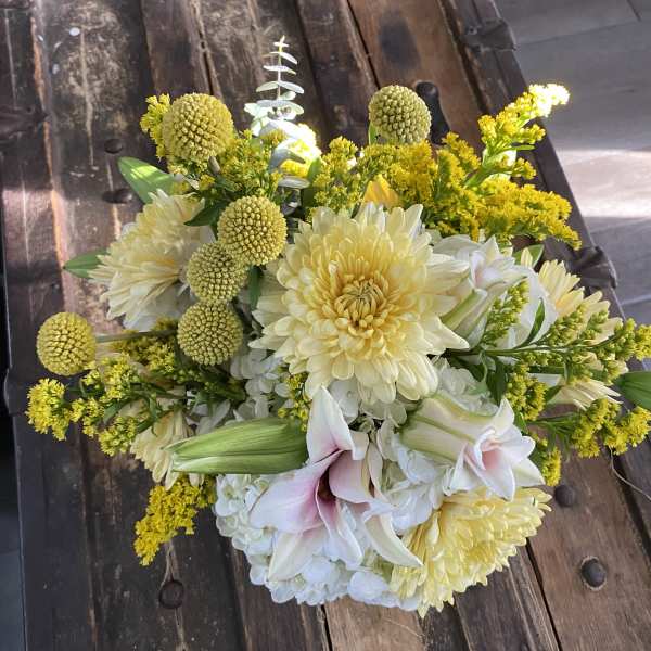 Bouquet of pale yellow and white flowers with pink lilies