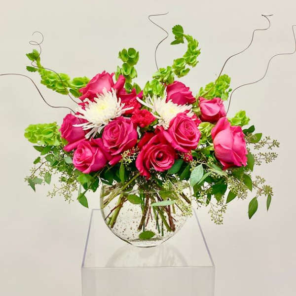 Pink roses and white spider mums in a clear glass vase