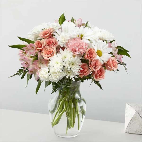 Pink roses and white daisies in a clear glass vase