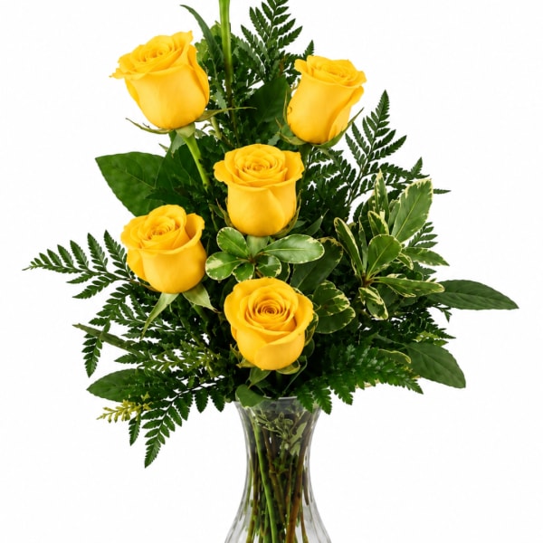 Yellow roses arranged in a clear glass vase with greenery