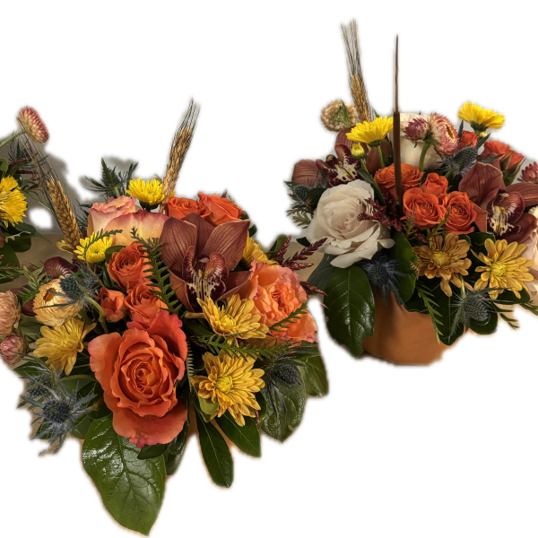 Three autumn floral arrangements with orange and cream roses in low containers