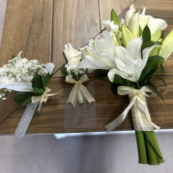 White lily bouquets with ribbon on a wooden table