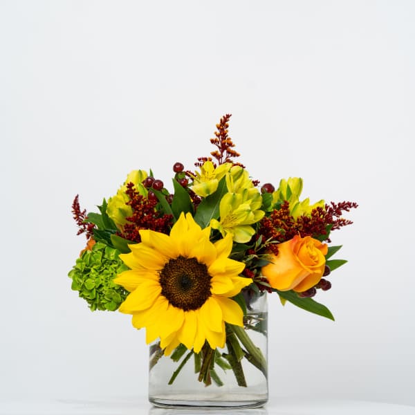 Sunflower and yellow alstroemeria arrangement in a clear glass vase