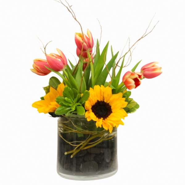 Tulips and sunflowers arranged in a glass vase