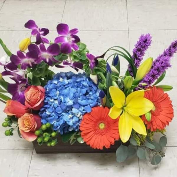 Colorful floral arrangement in a rectangular wooden container