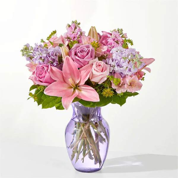 Pink and lavender bouquet in a purple glass vase
