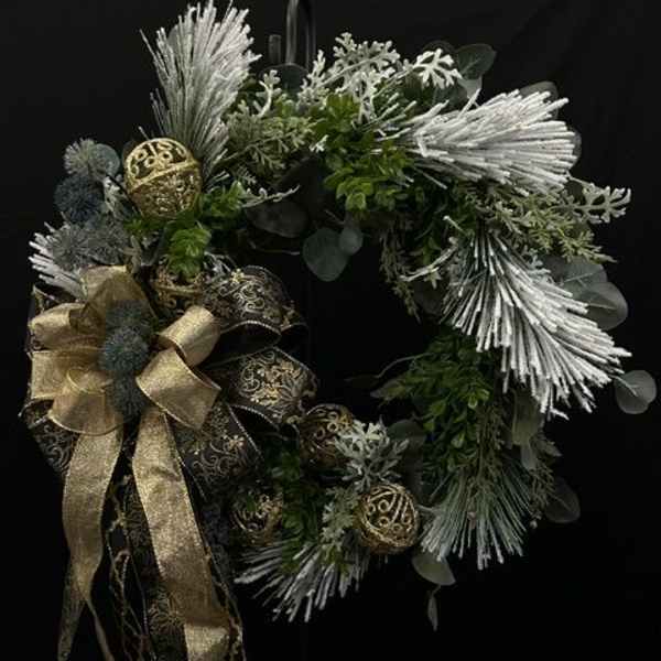 Holiday wreath with silver accents, gold ribbon, and dark greenery