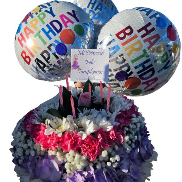 Birthday balloon bouquet above a colorful flower arrangement with candles