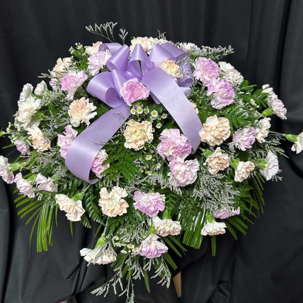 Lavender and white carnation spray with a purple ribbon