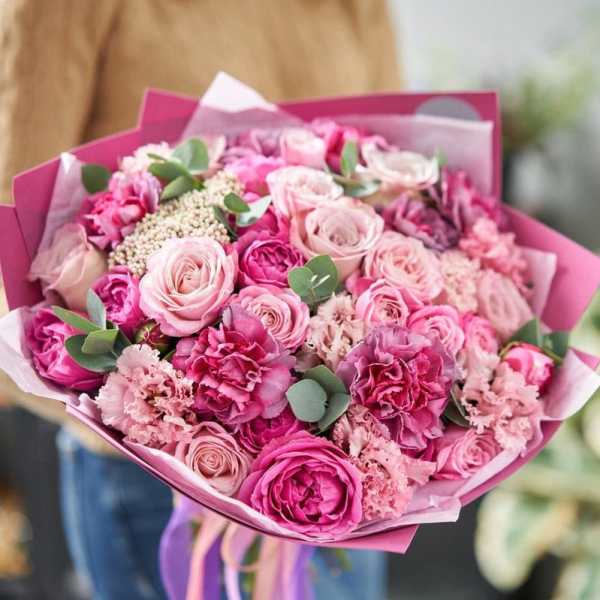 Pink bouquet of roses and carnations wrapped in magenta paper