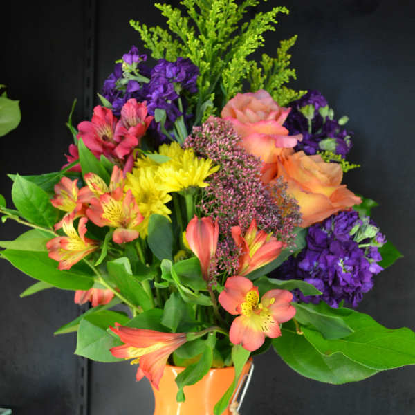 Colorful mixed bouquet in an orange vase