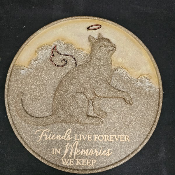 Round memorial plaque with a cat silhouette and the words "Friends live forever in memories we keep"