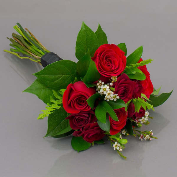 Bouquet of red roses with green leaves and small white filler flowers