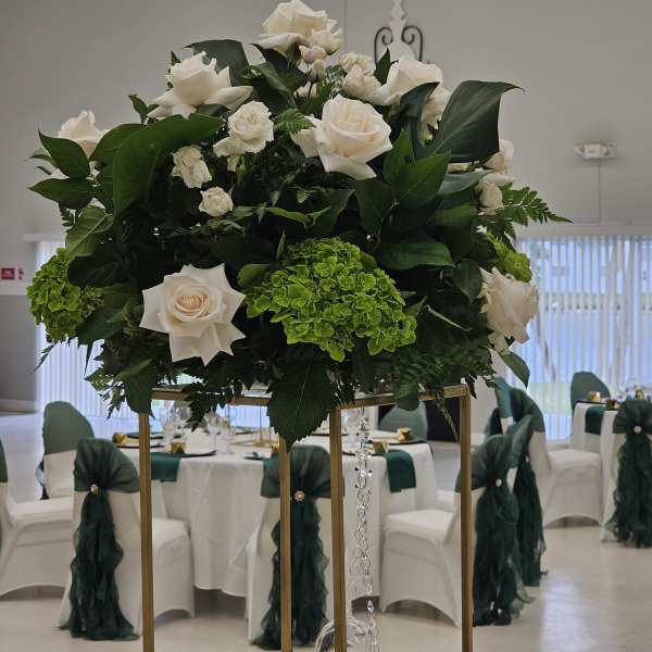 Large white rose arrangement on a tall gold stand