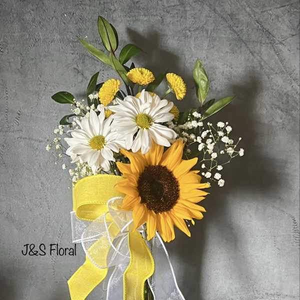 Sunflower and white daisy bouquet in a glass vase with yellow ribbon