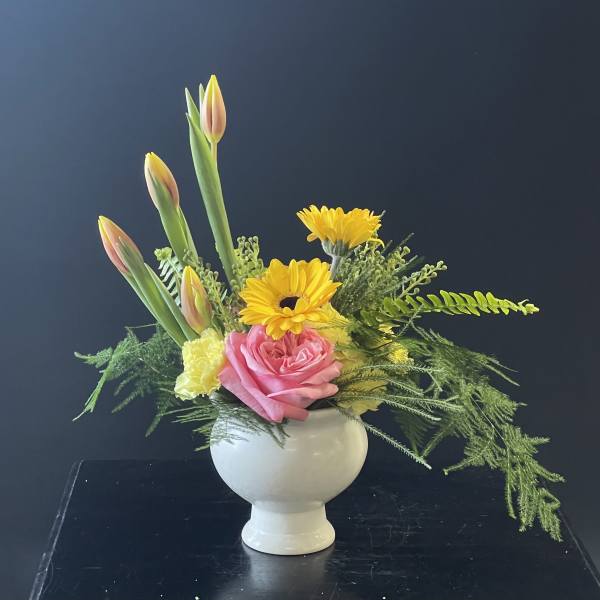 Pink rose and yellow daisy arrangement in a white vase