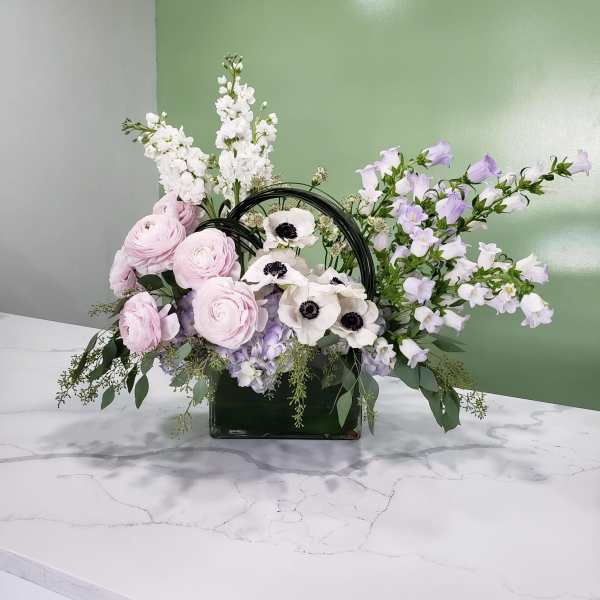 Pastel floral arrangement in a glass vase with pink, white, and lavender blooms