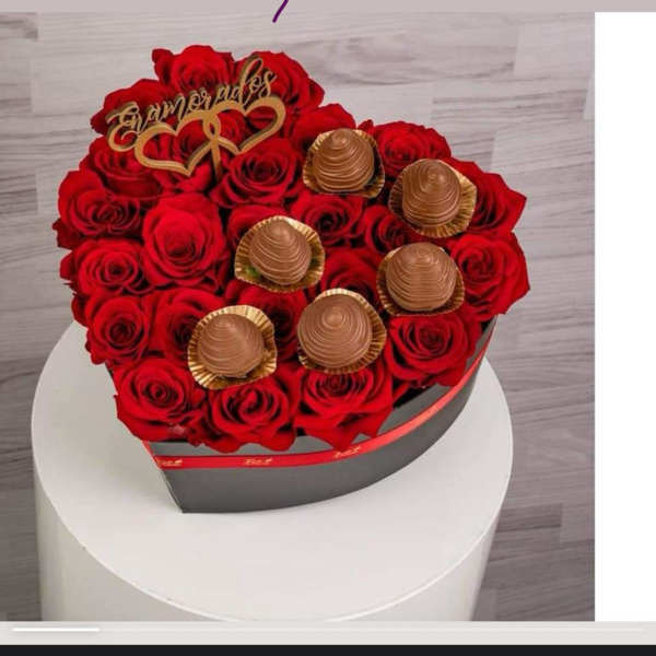 Heart-shaped box of red roses with chocolates on top
