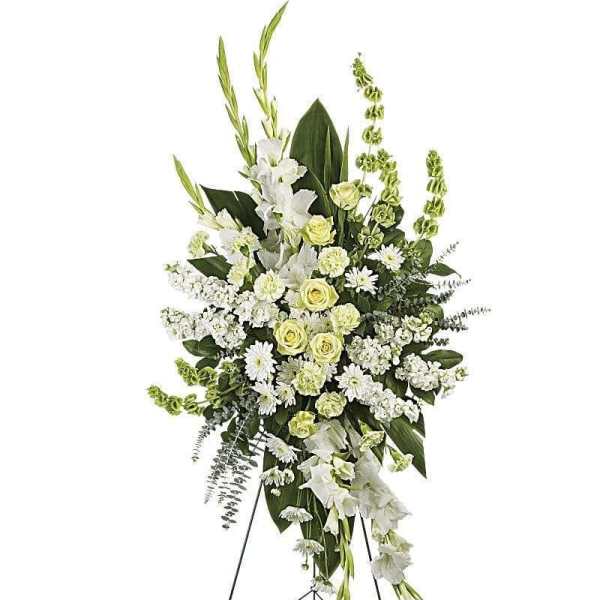 Tall white and pale green funeral spray on a stand
