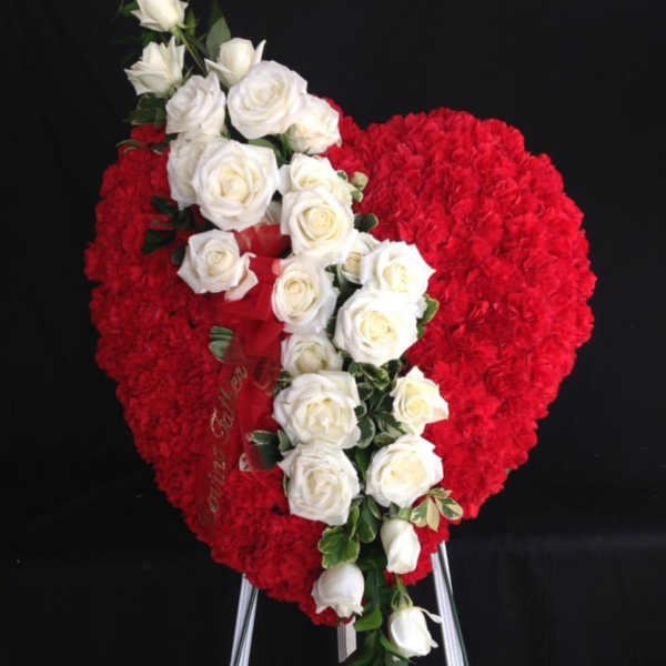 Heart-shaped red floral wreath with a diagonal spray of white roses