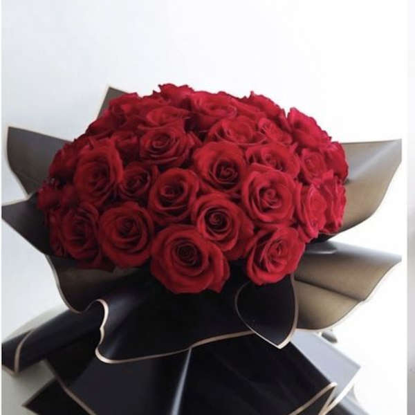 Bouquet of red roses wrapped in black and beige paper