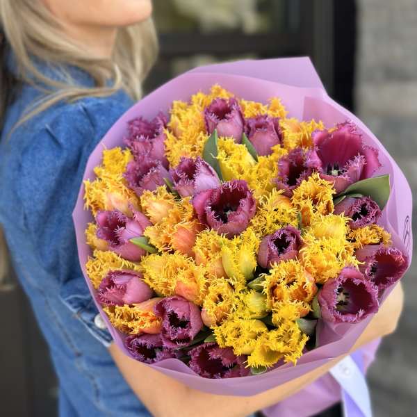 Bouquet of purple and yellow fringed tulips wrapped in pink paper
