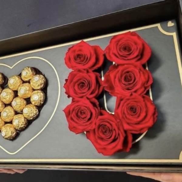 Boxed arrangement of red roses and Ferrero Rocher chocolates in heart shapes