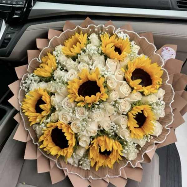 Bouquet of sunflowers and white roses wrapped in brown paper