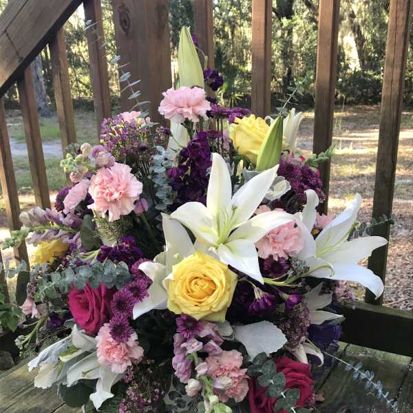 Bouquet with white lilies, yellow and pink roses, and purple flowers