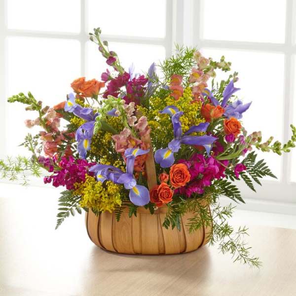 Colorful mixed flower arrangement in a wooden basket