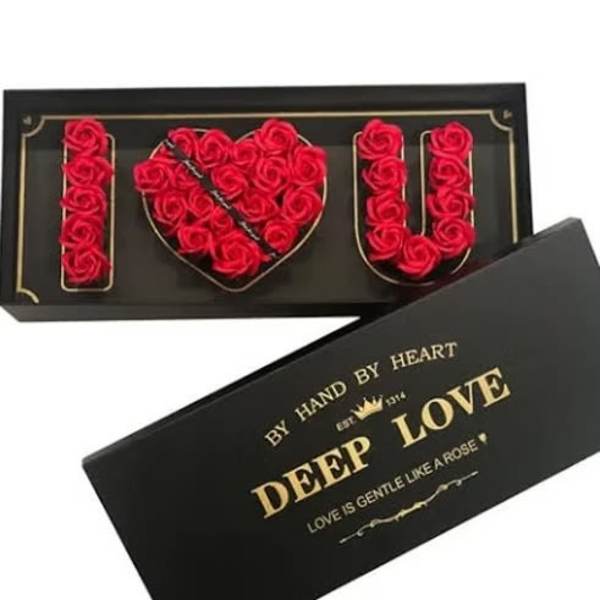 Black gift box with red roses arranged to spell I heart U