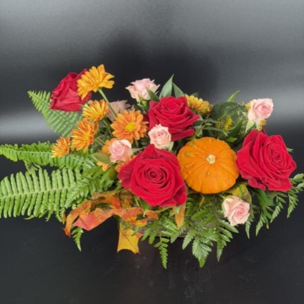 Bouquet of red roses, orange mums, and small pink roses with fern foliage