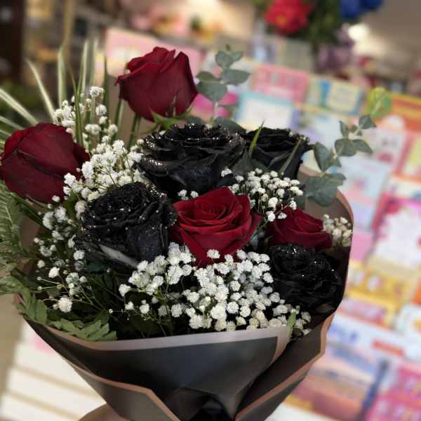 Bouquet of red and black roses with baby's breath in black wrap
