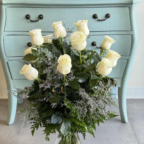 White roses arranged in a clear glass vase