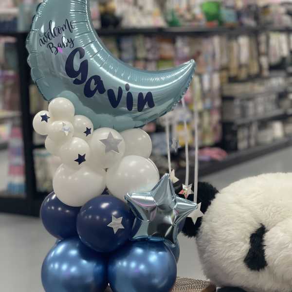 Blue moon balloon with white and navy balloons and a teddy bear
