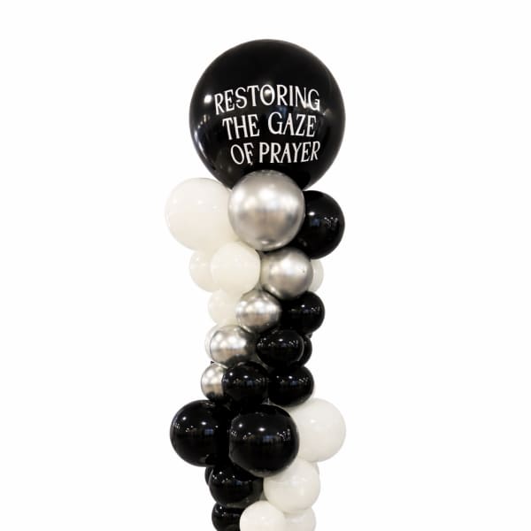 Black, white, and silver balloon column with a large printed top balloon