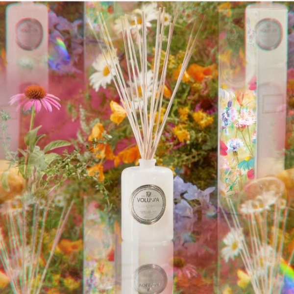 White reed diffuser bottle with floral packaging and colorful flowers
