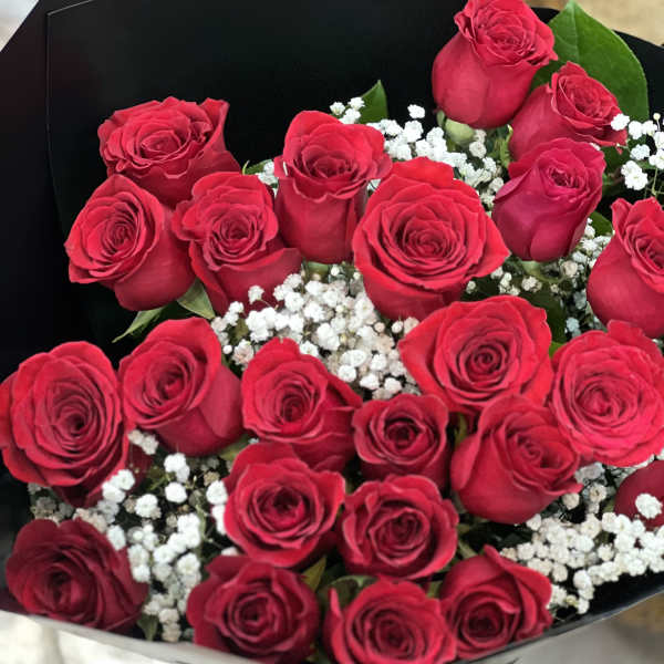 Bouquet of red roses with white baby's breath in black wrapping