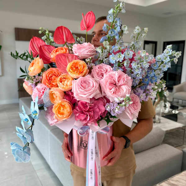 Large mixed bouquet in a pink hatbox with roses and blue flowers
