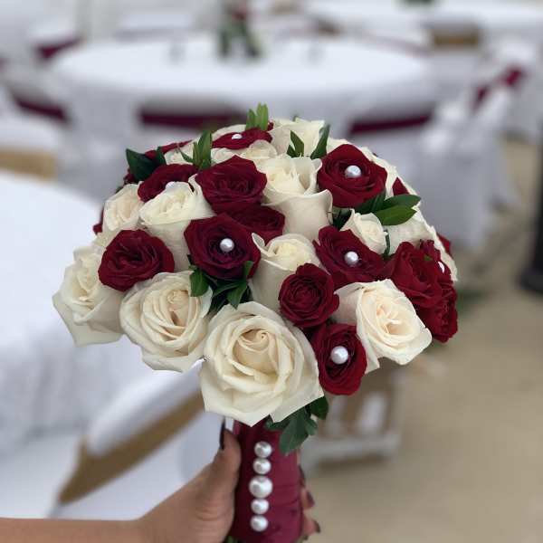 Handheld bouquet of red and white roses with pearl accents