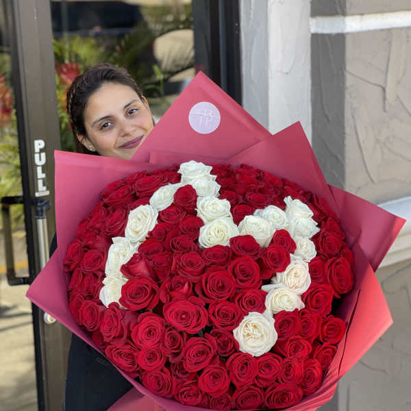 Large bouquet of red and white roses wrapped in pink paper