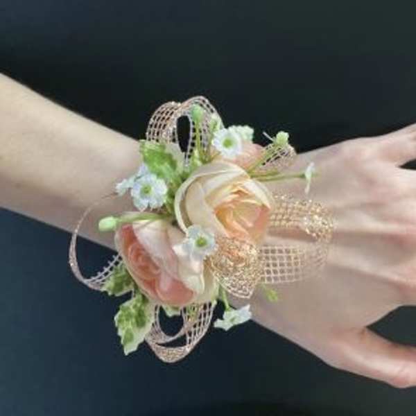 Peach and white floral wrist corsage with ribbon loops