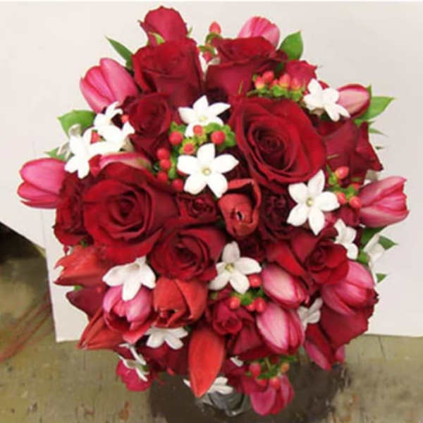 Bouquet of red roses, pink tulips, and white star-shaped flowers