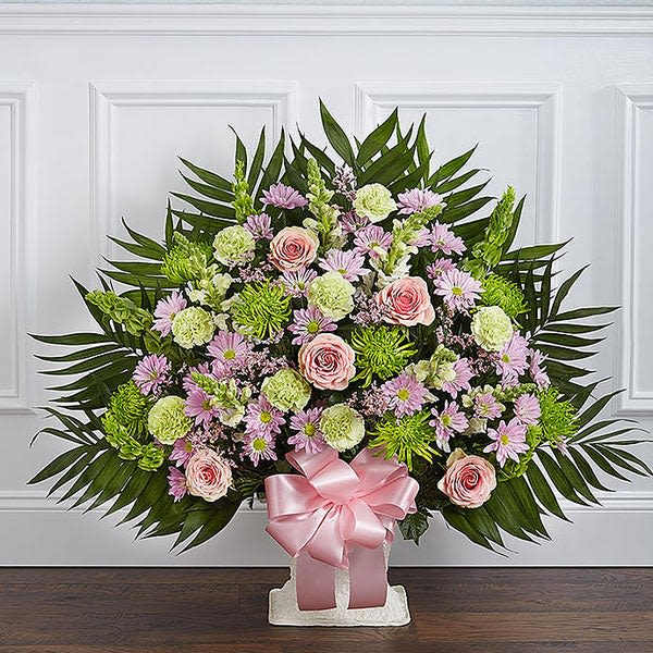 Large floral standing spray with pink roses and lavender daisies on a white stand