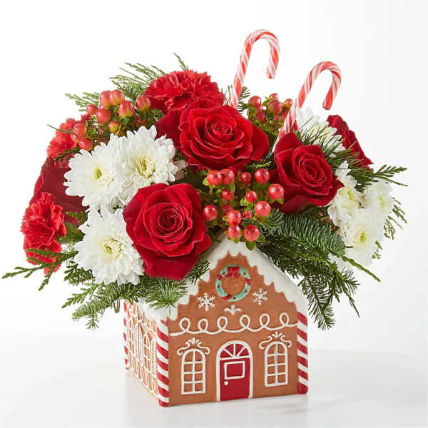 Christmas bouquet in a gingerbread house container with red roses and white daisies