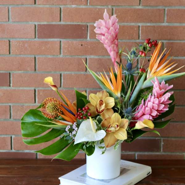 Tropical bouquet in a white vase with pink and orange flowers