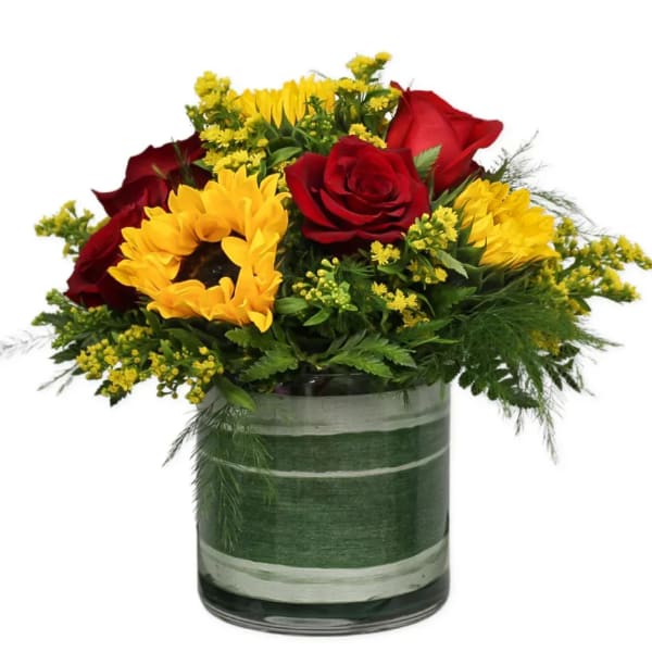 Bouquet of red roses and yellow sunflowers in a glass vase