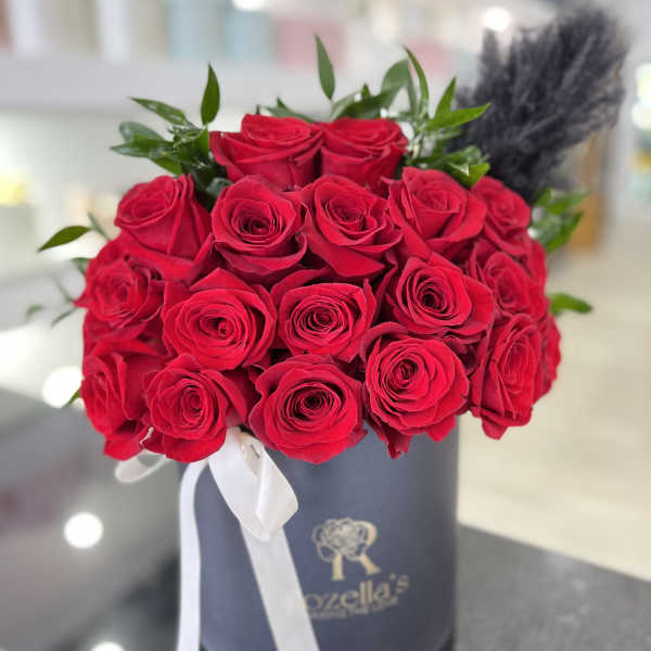 Bouquet of red roses in a gray hat box with a white ribbon